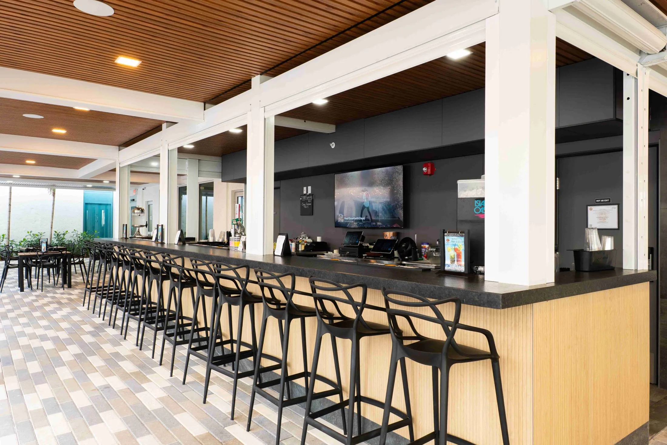 A long bar with black stools and a black countertop