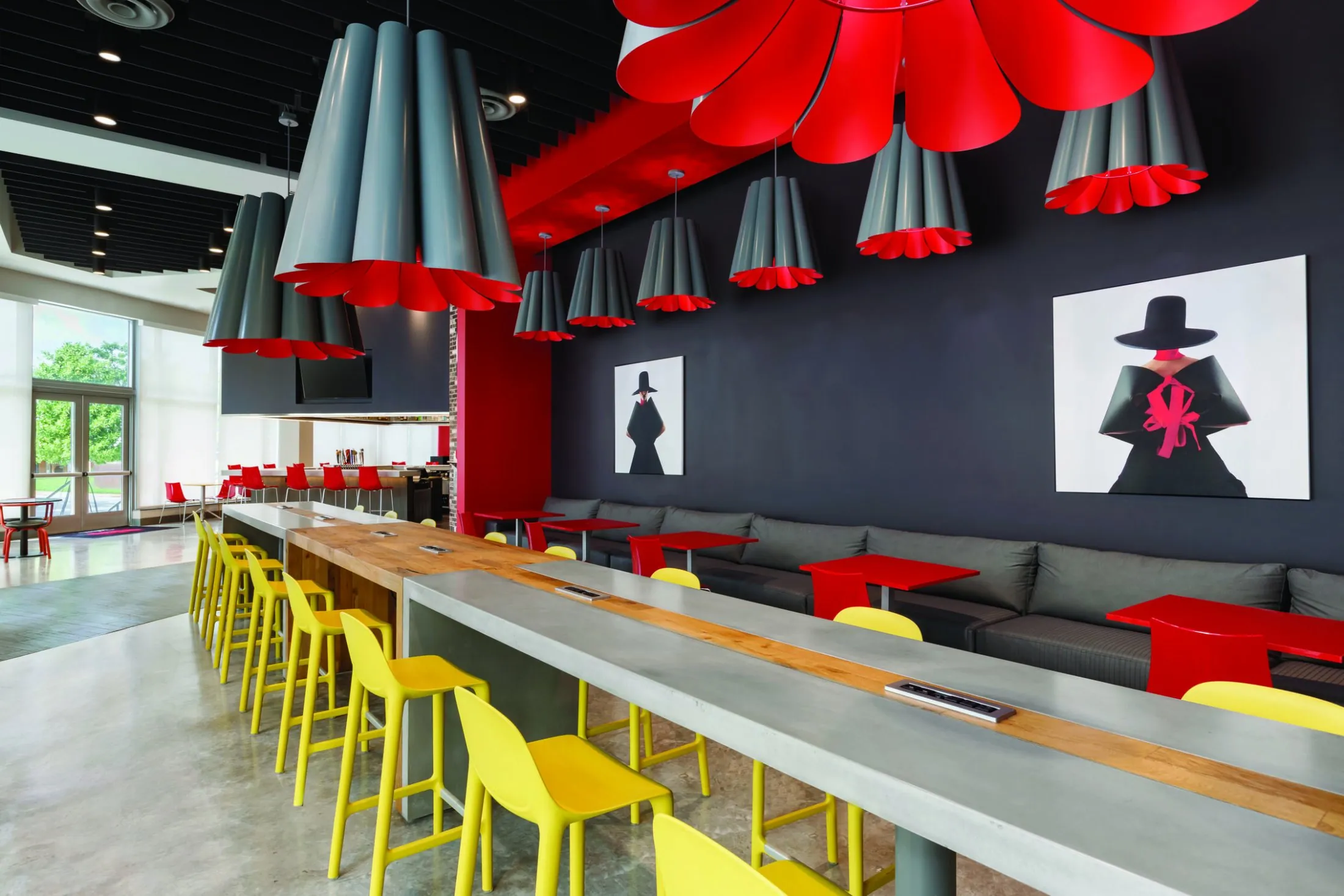 A modern lounge area with a bar, seating, and artwork.